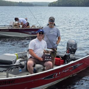 Mark Ristow and Patrick Robertson hold the fishing trophy in their boat on Percy Lake.