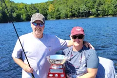 Mark and Jody Ristow in their fishing boat with the Percy Lake Bass Fishing trophy.