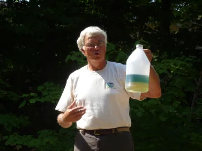 Jim Richert holding up a transparent can of separated gasoline