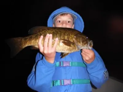 Leandro holding up a fish outside at night