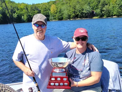Mark and Jody Ristow in their fishing boat with the Percy Lake Bass Fishing trophy.