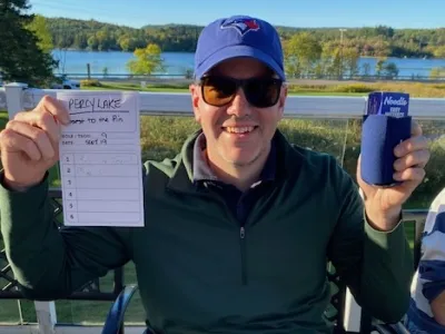 Mike Swan, closest to the pin, holding up his scorecard
