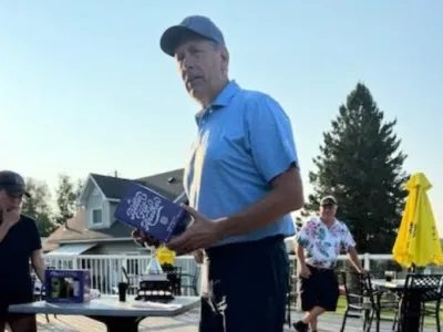 Bruce holds a prize he won for being tied for the longest drive.