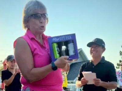 Diane holds up a prize she won for being tied for the longest drive.