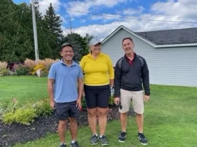A team of three golfers pose together at the Lakeside Golf Course.