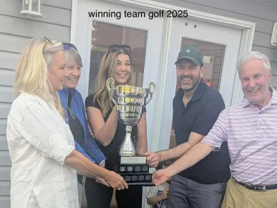 The 2025 winning team holding the trophy outside the clubhouse
