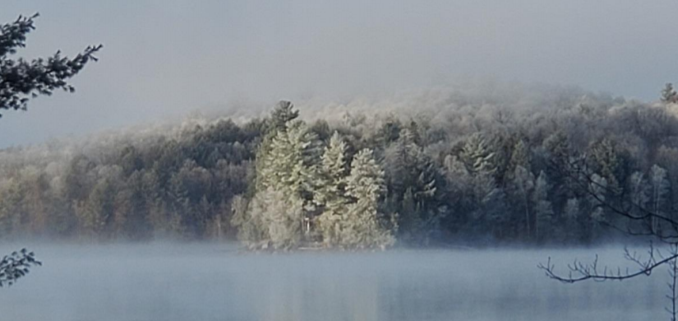 A misty shot of Percy Lake with snow covered trees.