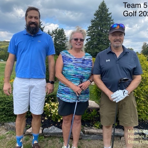 Three golfers that make up team 5 pose with clubs in hand.