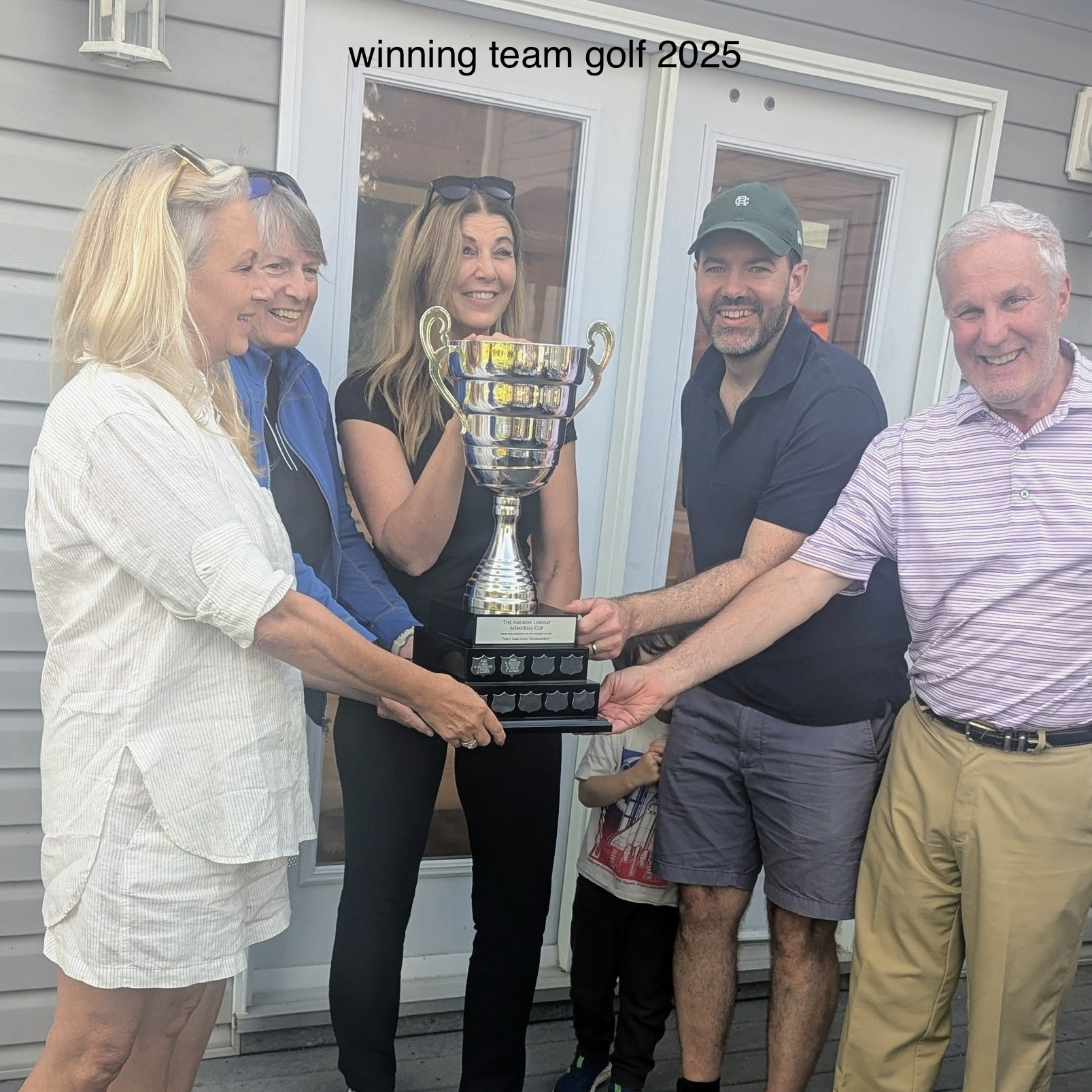 A team of four golfers is presented a large trophy.