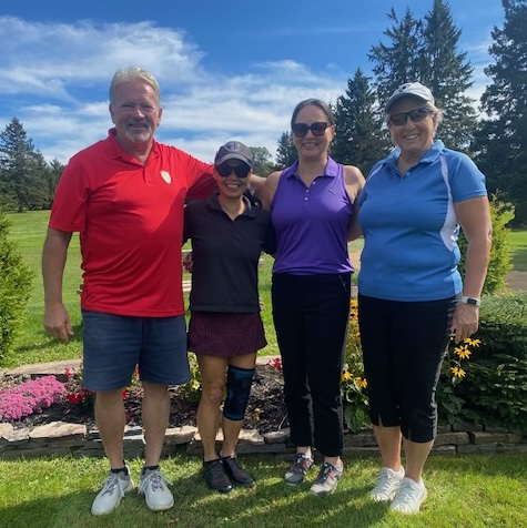 A team of golfers, one man and three women.